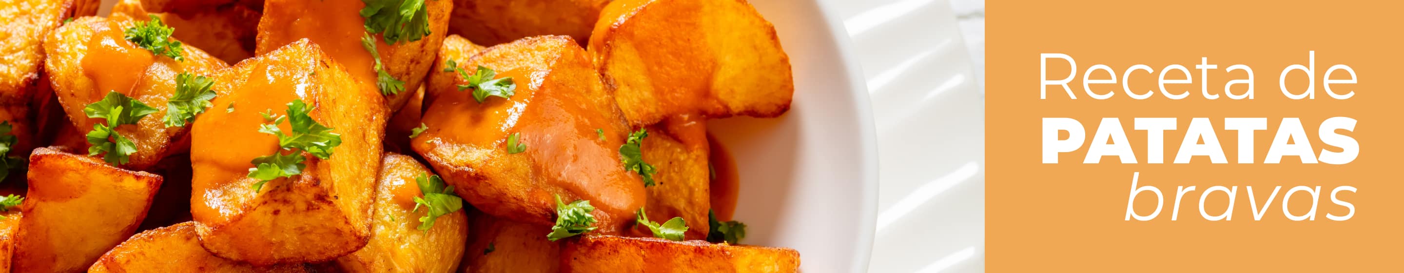 Plato de cerámica con patatas bravas caseras recién hechas y salsa brava.
